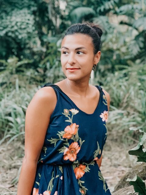 Sabrina in a flowered dress in a tropical garden, looking to the side